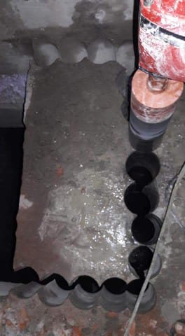 تنفيذ فتحات دائرية في أرضية خرسانية باستخدام معدات متخصصة.